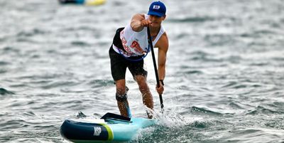 An elite stand-up paddleboard racer mid-stroke during the ICF SUP World Cup