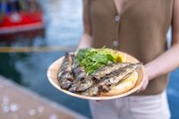 A plate of charcoal-grilled sardines with salad and bread, held harbour-side at the South West Sardine Festival