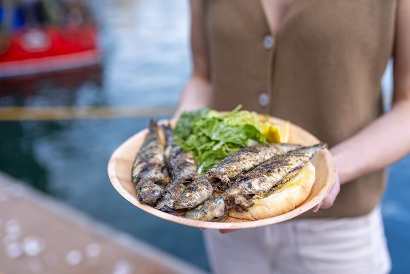 A plate of charcoal-grilled sardines with salad and bread, held harbour-side at the South West Sardine Festival